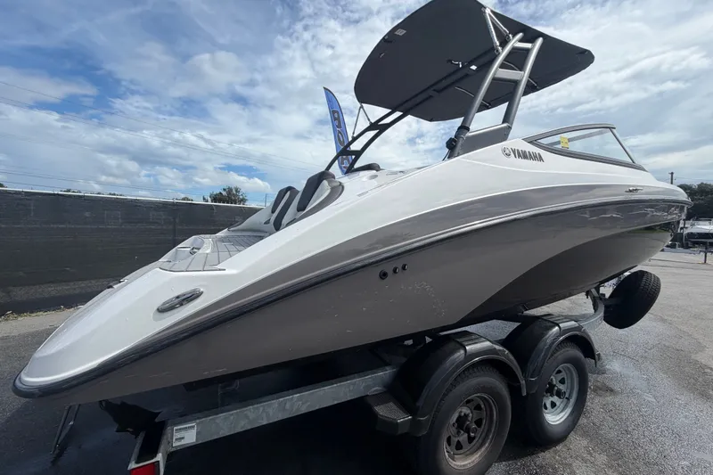 Slide: The Image of 2022 Yamaha Boats AR210 on trailer under cloudy sky. - 2