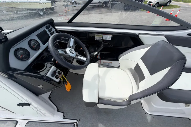 Slide: The Image of 2022 Yamaha Boats AR210 cockpit with steering wheel, gauges, and comfortable seating. - 22