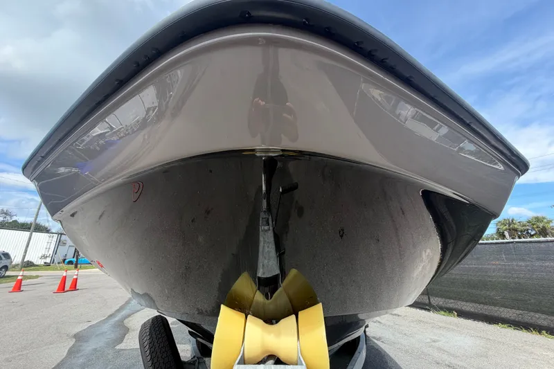 Slide: The Image of 2022 Yamaha AR210 boat hull close-up, parked on trailer under blue sky. - 8