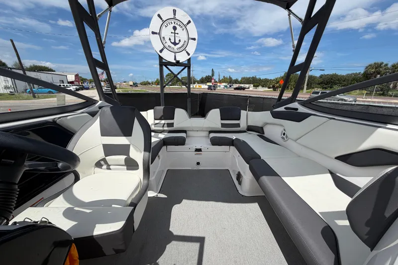 Slide: The Image of 2022 Yamaha Boats AR210 interior with spacious seating and modern design under a clear sky. - 50