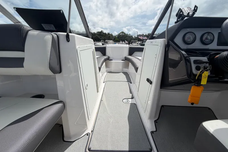 Slide: The Image of 2022 Yamaha Boats AR210 interior with seating, dashboard, and storage compartments. - 30