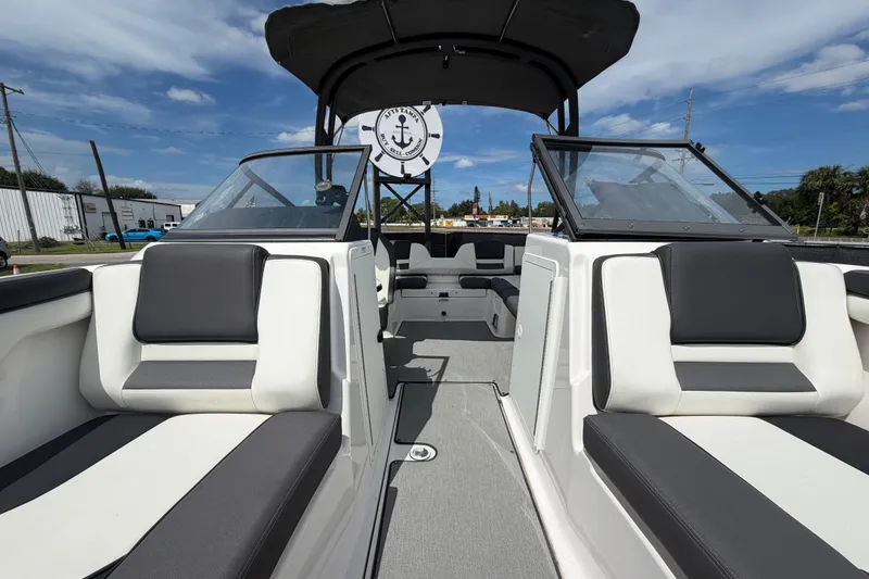 Slide: The Image of 2022 Yamaha Boats AR210 interior with sleek seating and modern design under a clear sky. - 48