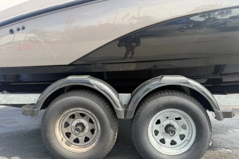 Slide: The Image of 2022 Yamaha Boats AR210 on trailer, showcasing dual wheels and sleek hull design. - 67