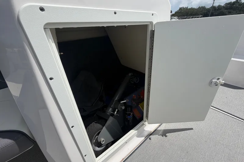 Slide: The Image of Open storage compartment on 2022 Yamaha AR210 boat, revealing interior equipment. - 34
