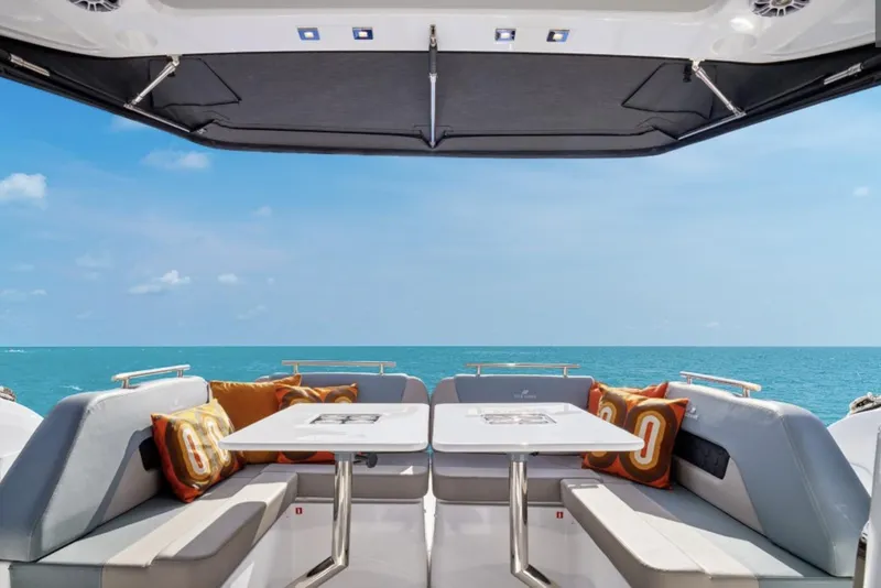 Slide: The Image of Manufacturer Provided Image: 2025 Four Winns TH36 yacht interior with ocean view, featuring seating and tables. - 5