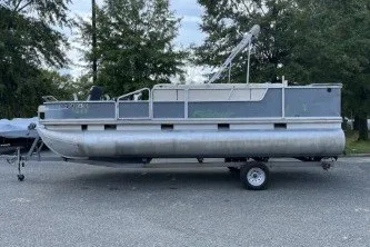 The Image of 2002 Fisher Freedom 220 DLX FISH pontoon boat on trailer, parked outdoors. - 1
