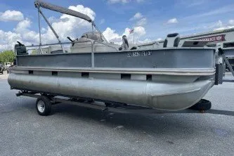 Slide: The Image of 2002 Fisher Freedom 220 DLX FISH pontoon boat on trailer under blue sky. - 4
