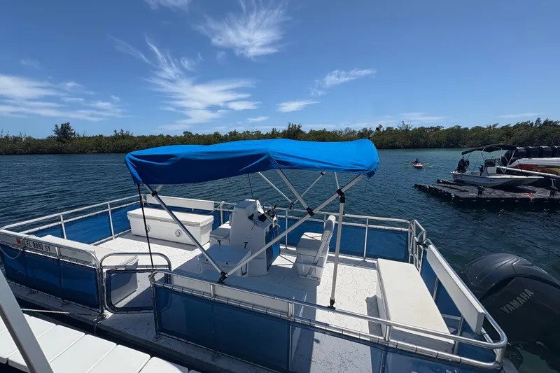Slide: The Image of 2021 A&M Manufacturing Salty boat with blue canopy on a sunny day by the water. - 10