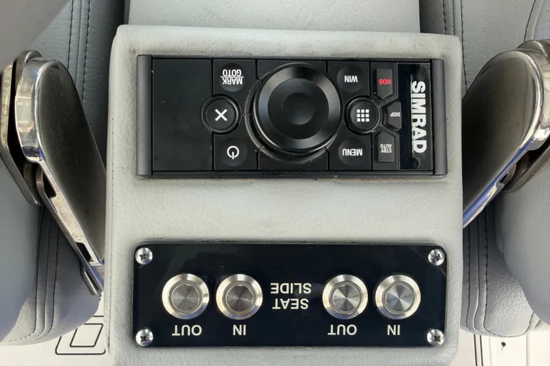 Slide: The Image of Simrad control panel and seat slide buttons on 2023 Sea Pro 320 DLX Offshore boat. - 40