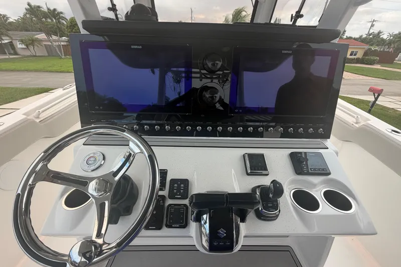 Slide: The Image of 2023 Sea Pro 320 DLX Offshore helm with dual Simrad displays and Suzuki controls. - 18