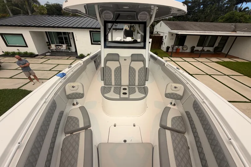 Slide: The Image of 2023 Sea Pro 320 DLX Offshore boat with luxurious seating in a residential driveway. - 34
