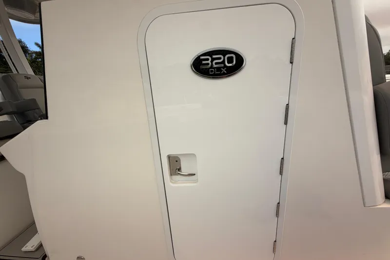 Slide: The Image of 2023 Sea Pro 320 DLX Offshore boat cabin door with model badge. - 30