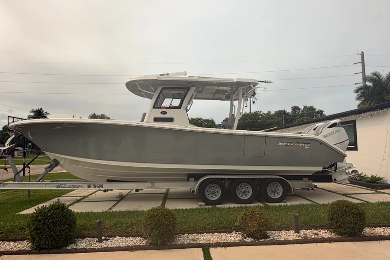 Slide: The Image of 2023 Sea Pro 320 DLX Offshore boat on trailer, parked in residential driveway. - 10
