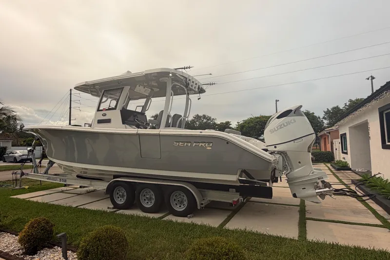 Slide: The Image of 2023 Sea Pro 320 DLX Offshore boat on trailer, parked in residential driveway. - 9