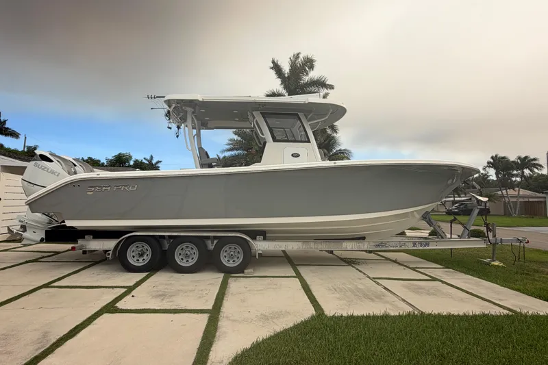 Slide: The Image of 2023 Sea Pro 320 DLX Offshore boat on trailer, parked in driveway. - 1