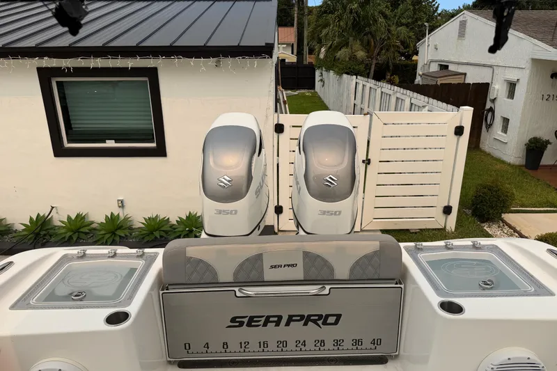 Slide: The Image of 2023 Sea Pro 320 DLX Offshore boat with dual Suzuki 350 engines, docked near a house. - 42