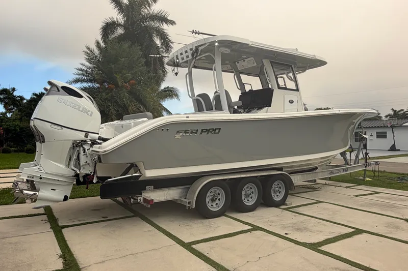 Slide: The Image of 2023 Sea Pro 320 DLX Offshore boat on trailer, featuring dual Suzuki outboard engines. - 3