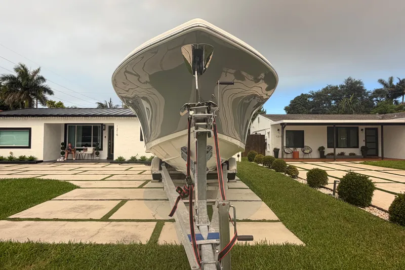 Slide: The Image of 2023 Sea Pro 320 DLX Offshore boat on trailer in residential driveway. - 12