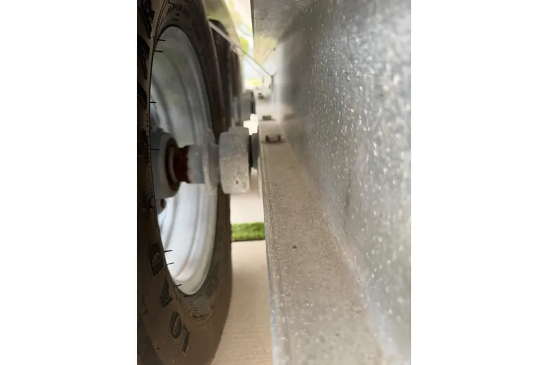 Slide: The Image of Close-up of a 2023 Sea Pro 320 DLX Offshore trailer wheel and axle. - 54