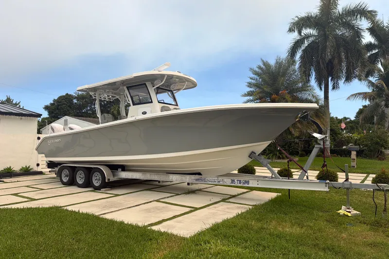 The Image of 2023 Sea Pro 320 DLX Offshore boat on trailer, parked in a tropical setting. - 0