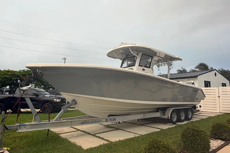 Slide: The Image of 2023 Sea Pro 320 DLX Offshore boat on trailer, parked in residential driveway. - 11
