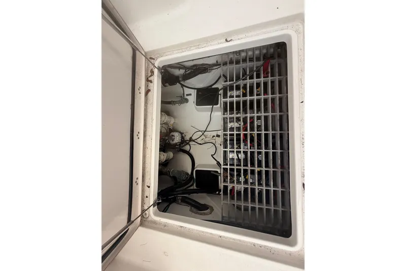 Slide: The Image of 2023 Sea Pro 320 DLX Offshore boat compartment with wiring and components visible. - 56