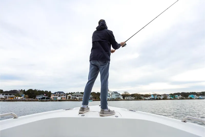 Slide: The Image of Person fishing on a 2026 Parker 180 Coastal boat near waterfront homes. - 4