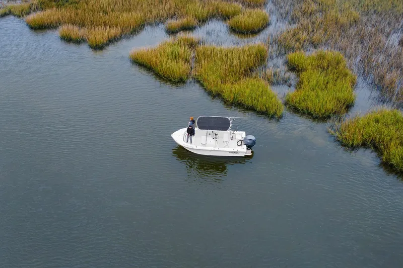 Slide: The Image of Aerial view of a 2026 Parker 180 Coastal boat navigating through marshland. - 5