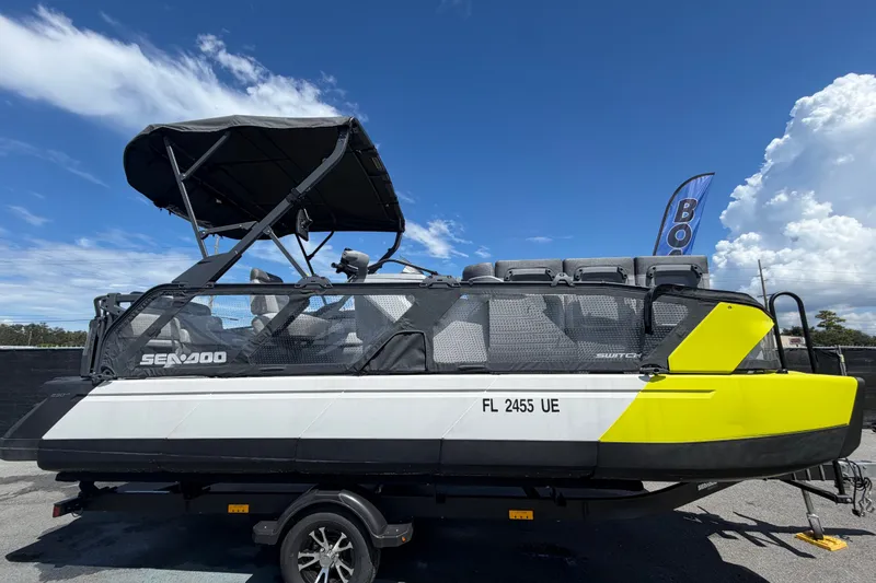 The Image of Un Sea-Doo Switch Cruise 21 del 2023 con accenti gialli su un rimorchio sotto un cielo azzurro. - 0