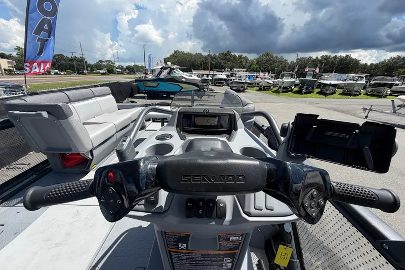 Slide: The Image of 2023 Sea-Doo Switch Cruise 21 dashboard with steering wheel and seating, under cloudy sky. - 38