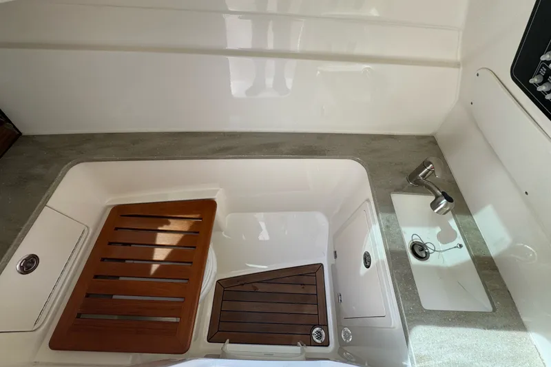 Slide: The Image of 2021 Boston Whaler 320 Vantage boat interior with sink and wooden accents. - 97