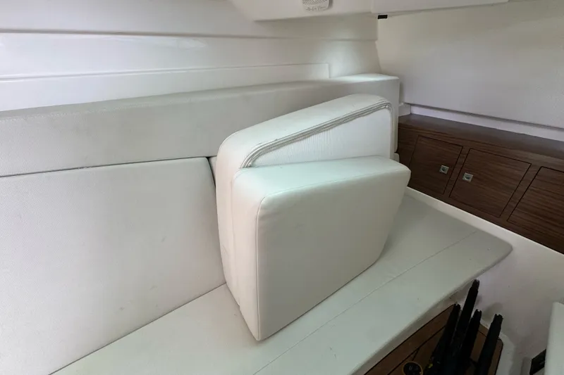 Slide: The Image of 2021 Boston Whaler 320 Vantage interior with white seating and wooden storage cabinets. - 72