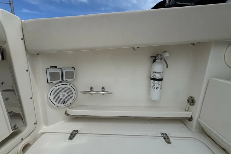 Slide: The Image of 2021 Boston Whaler 320 Vantage interior with speaker, fire extinguisher, and storage compartment. - 33
