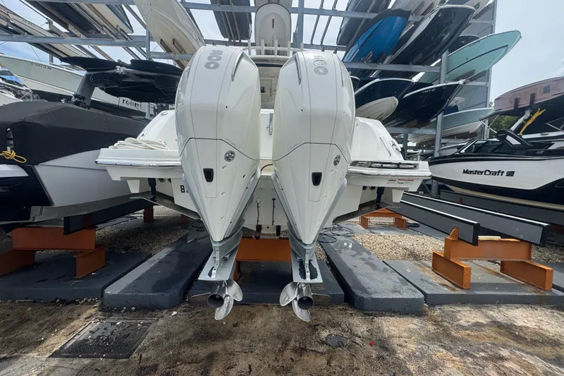 Slide: The Image of 2021 Boston Whaler 320 Vantage with dual outboard engines in a boat storage facility. - 14