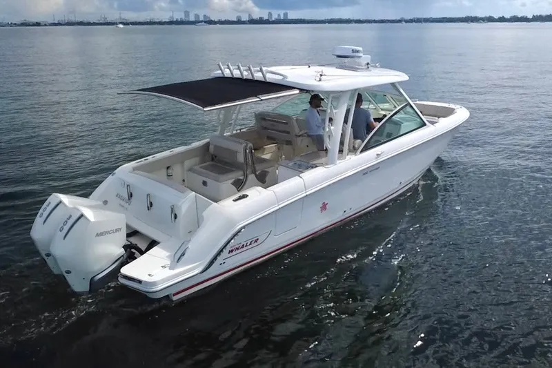 Slide: The Image of 2021 Boston Whaler 320 Vantage boat cruising on calm water, featuring dual Mercury engines. - 3
