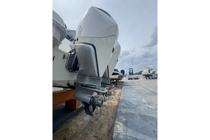 Slide: The Image of 2021 Boston Whaler 320 Vantage boat engine, docked on a concrete surface under cloudy skies. - 17