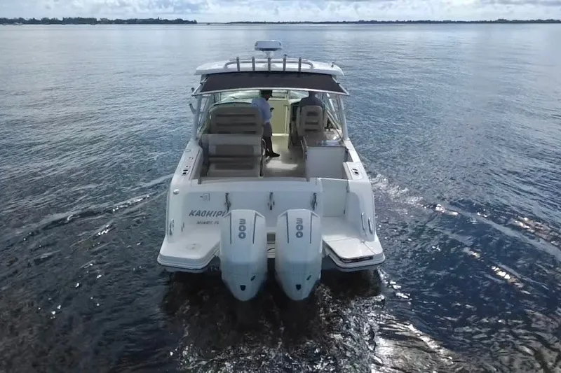 Slide: The Image of 2021 Boston Whaler 320 Vantage cruising on calm waters, rear view. - 4