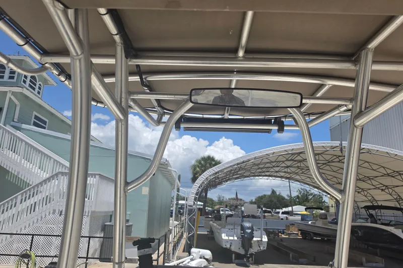 Slide: The Image of 2021 Bulls Bay 2200 boat with T-top frame, docked under a canopy. - 49