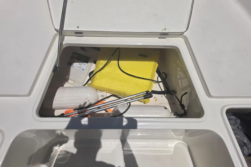 Slide: The Image of Open storage compartment on a 2021 Bulls Bay 2200 boat, containing various equipment. - 65
