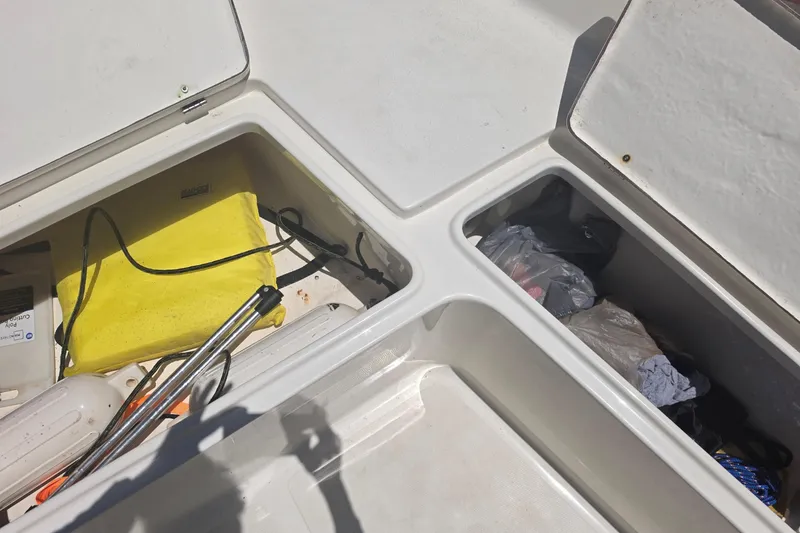 Slide: The Image of Open storage compartments on a 2021 Bulls Bay 2200 boat, featuring various equipment and items. - 64