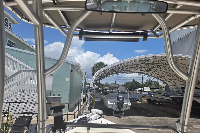 Slide: The Image of 2021 Bulls Bay 2200 boat under canopy, surrounded by other boats and buildings. - 50