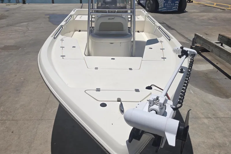 Slide: The Image of 2021 Bulls Bay 2200 boat docked at a marina, featuring a trolling motor. - 16