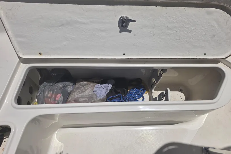 Slide: The Image of Open storage compartment on a 2021 Bulls Bay 2200 boat, containing ropes and gear. - 63