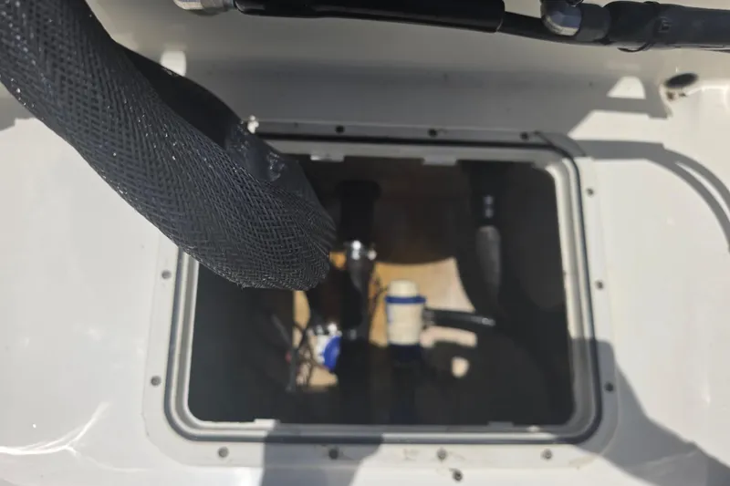 Slide: The Image of 2021 Bulls Bay 2200 boat compartment with visible hoses and fittings. - 88