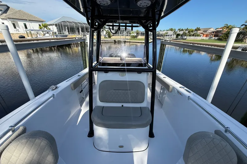 Slide: The Image of 2023 Sportsman Heritage 241 Center Console boat docked by a serene waterfront. - 45