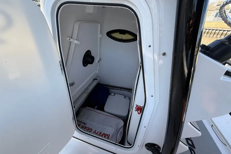 Slide: The Image of 2023 Sportsman Heritage 241 Center Console interior storage compartment with safety gear. - 27
