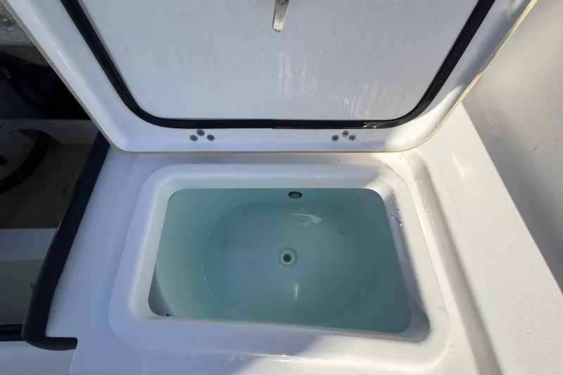 Slide: The Image of Open storage compartment on 2023 Sportsman Heritage 241 Center Console boat. - 59