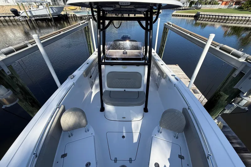 Slide: The Image of 2023 Sportsman Heritage 241 Center Console boat docked by a serene waterfront. - 43