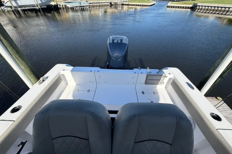 Slide: The Image of 2023 Sportsman Heritage 241 Center Console boat at dock, rear view with seating and motor. - 54