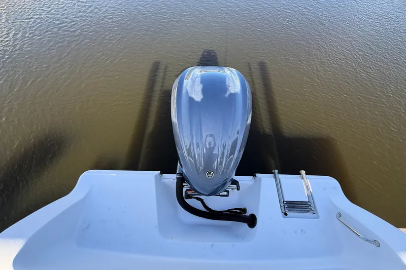 Slide: The Image of 2023 Sportsman Heritage 241 Center Console boat engine and swim platform on water. - 62